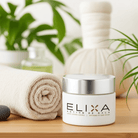 Elixa crème Défense Action de Gala sur table en bois clair avec serviette roulée beige.
